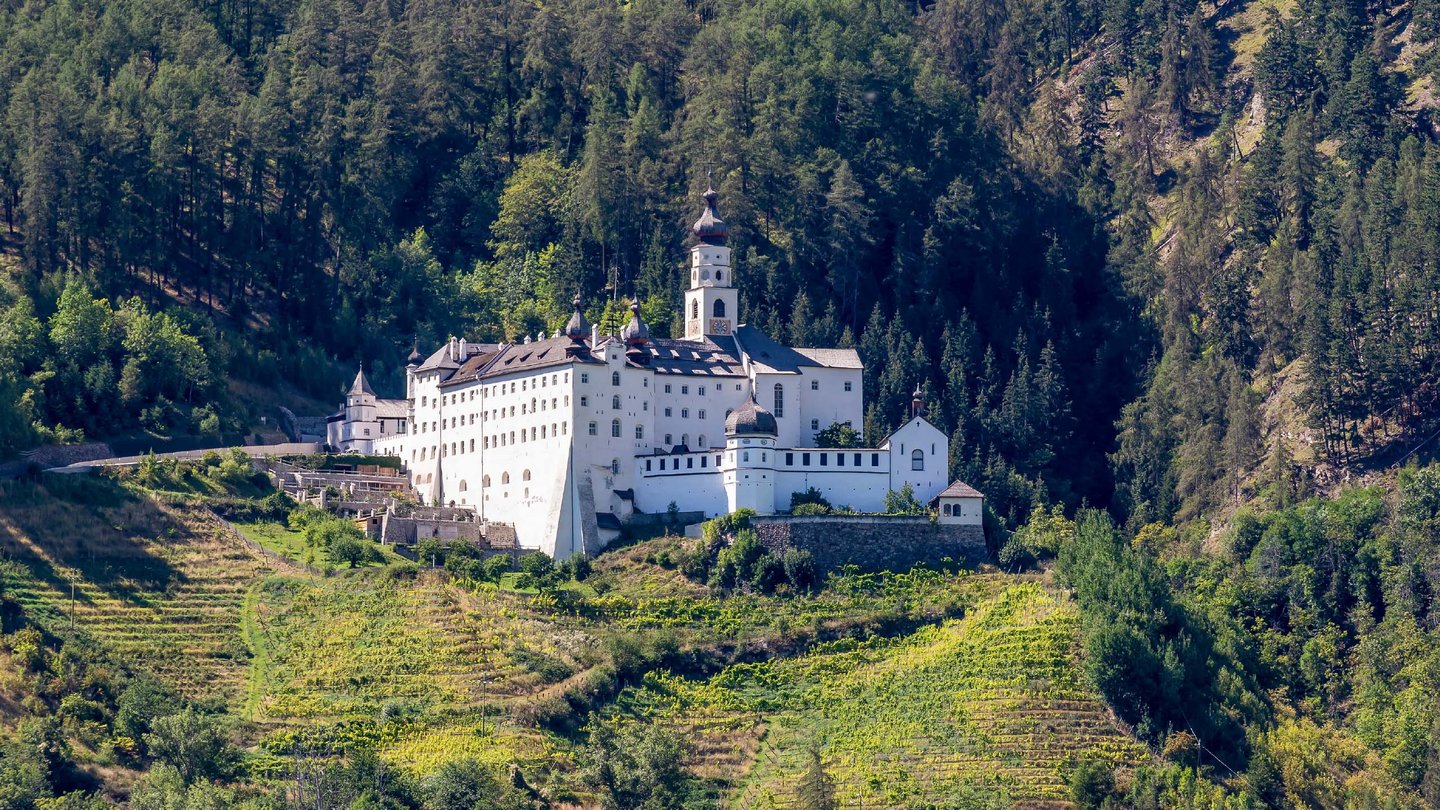 Marienberg Abbey, nestled in the greenery of South Tyrol, stands majestically on a hill surrounded by vineyards.